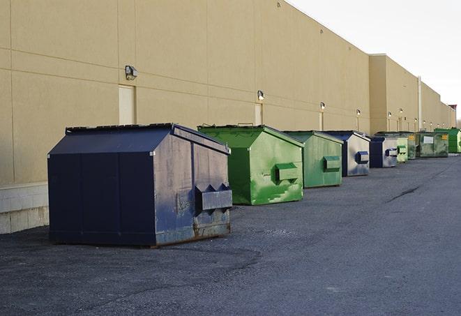 a fleet of red and blue construction dumpsters available for use in Brighton